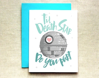 Könnte beinhalten: Eine weiße Karte mit einer grauen und weißen Illustration des Todessterns aus Star Wars. Der Todesstern hat ein rosa Herz in der Mitte. Die Karte sagt "Til Death Star Do You Part" in türkisfarbener Schrift.