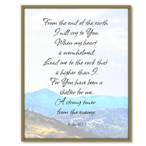 May include: A framed print featuring a watercolor landscape of blue and brown mountains under a light blue sky. The print includes a quote from Psalm 61:2-3 in elegant black script. The frame is a gold color.