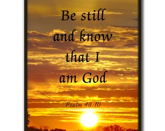 May include: A framed print with a sunset background and the text "Be still and know that I am God, Psalm 46:10".