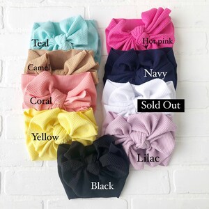 May include: Assortment of fabric headbands in various colors, including teal, camel, coral, yellow, black, lilac, hot pink, navy, and white. Some headbands are sold out.