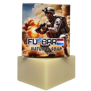 May include: A bar of natural soap with a label that says "FU*BAR NATURAL SOAP 5.56 oz. of FREEDOM". The label features a cartoon image of a soldier holding a gun and a backpack, with an explosion in the background.