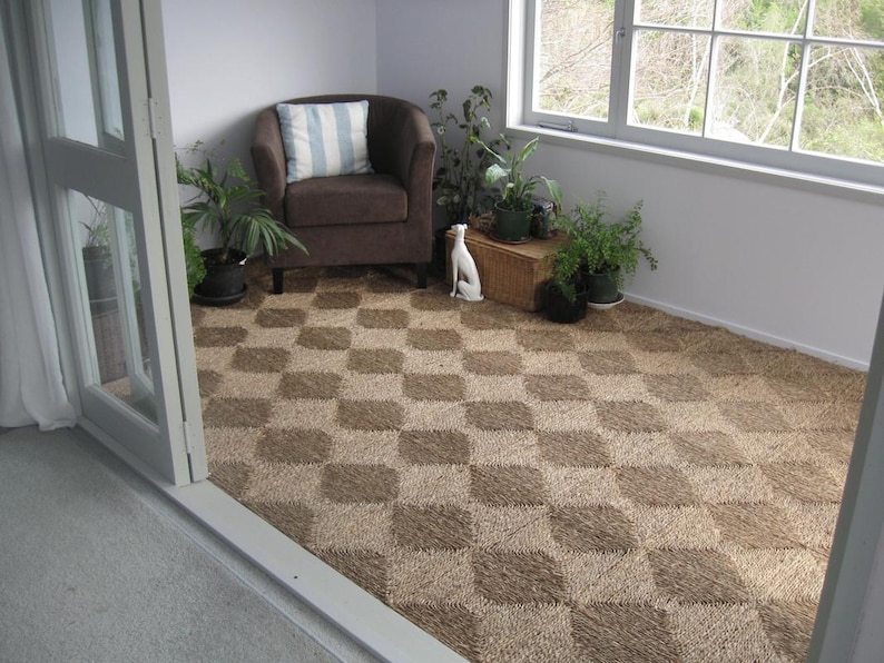 May include: A brown armchair with a blue and white patterned cushion sits in a room with a checkered brown and white floor. A white ceramic dog figurine sits on the floor in front of the chair.
