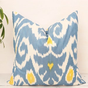 May include: A blue and white throw pillow with a yellow ikat pattern.