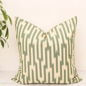 May include: A green and cream striped throw pillow with a geometric pattern.