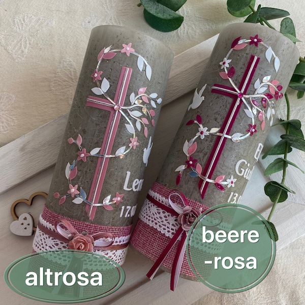 May include: Two cylindrical gray candles decorated with a pink cross, white and pink floral vines, and a white dove. The base of each candle features a pink burlap band, white lace trim, a small fabric rose, and a ribbon. Text includes names and dates.