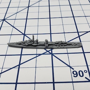 May include: A gray plastic model of a destroyer ship. The ship has a long, narrow hull with a raised deck and a single smokestack. The model is detailed with guns, lifeboats, and other features.