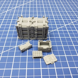 May include: A set of five gray plastic containers with various sizes and shapes. The containers have a textured surface and are stacked on top of each other.