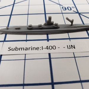 Puede incluir: Un modelo de submarino de plástico gris con la etiqueta "Submarine: I-400 - IJN".