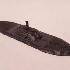May include: A black model of a Civil War era ironclad warship with a raised deck and a single smokestack.