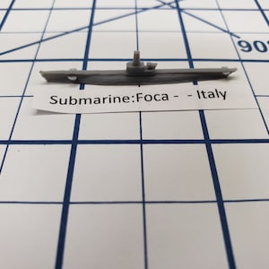 May include: A gray model of a submarine labeled "Submarine: Foca - Italy".