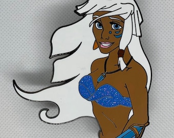 Puede incluir: Un pin que representa a una mujer de dibujos animados con cabello blanco y piel morena. Lleva un top azul, un collar y una pulsera. El pin tiene un contorno negro y está sobre un fondo blanco.