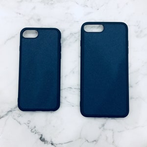 May include: Two black phone cases with a textured surface. The cases are different sizes.