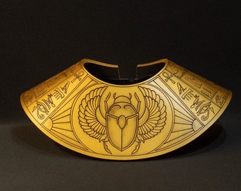 Könnte beinhalten: Ein goldfarbener Kragen mit einem ägyptischen Skarabäus-Design und Hieroglyphen. Der Kragen ist aus einem leichten Material gefertigt und perfekt für ein Kostüm oder Cosplay.