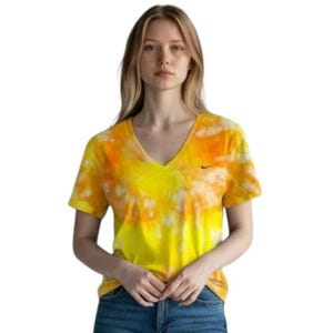 May include: A short-sleeve V-neck t-shirt featuring a vibrant tie-dye pattern in shades of bright yellow and orange. The garment includes a small black Nike swoosh logo embroidered on the left side of the chest, set against a plain white background.