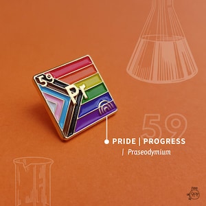 Op de afbeelding: Een gouden emaille pin met het chemische symbool voor Praseodymium (Pr) met het atoomnummer 59. De pin is ontworpen om te lijken op een regenboogvlag met de tekst "PRIDE | PROGRESS" en "Praseodymium" eronder.