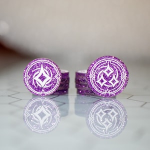 May include: Two purple glitter tokens with a white symbol of a diamond inside a circle. The tokens are stacked on top of each other.