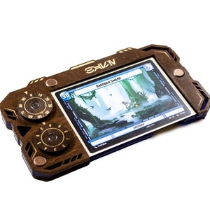 May include: A wooden game console with a card displayed in the screen. The card shows a swamp scene with the text "Bagorrah Swamp". The console has two dials with numbers on them.