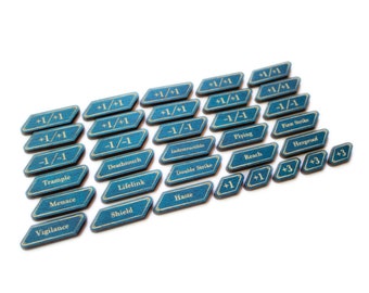Könnte beinhalten: Ein Satz von 20 blauen und goldenen Zählmarken für Tabletop-Rollenspiele. Die Marken zeigen verschiedene Fähigkeiten und Modifikatoren, darunter +1/+1, -1/-1, Trampeln, Todesberührung, Lebensverknüpfung, Schild, Wachsamkeit, Eile, Fliegen, Erstschlag, Reichweite, Hexensicher und +3.