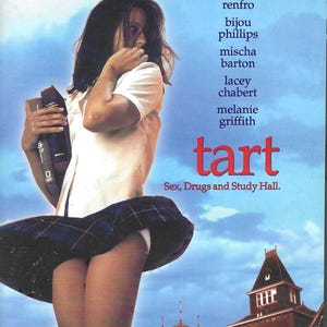 May include: A DVD cover for the film Tart featuring a person in a white shirt and a dark blue plaid skirt holding books. The text includes the names Dominique Swain, Brad Renfro, Bijou Phillips, Mischa Barton, Lacey Chabert, Melanie Griffith, and the title Tart.