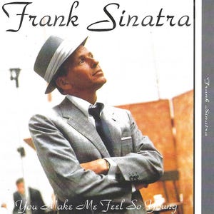 May include: A black and white photo of Frank Sinatra wearing a grey suit and a fedora. The text "You Make Me Feel So Young" is at the bottom of the image.