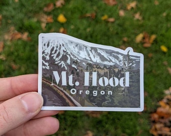 May include: A white sticker with a photo of a mountain range with snow on the peaks. The text "Mt. Hood Oregon" is printed in white on the sticker.