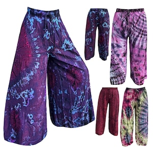 Op de afbeelding: Vijf paar wijde broek met tie-dye patronen in verschillende kleuren, waaronder paars, roze, rood en groen.