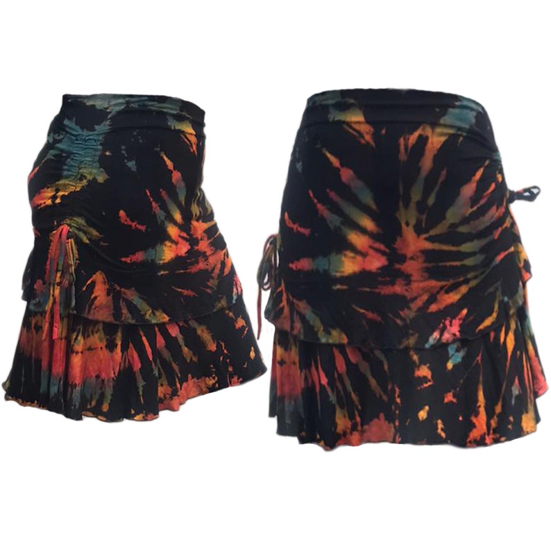 Peut inclure: Une jupe noire avec un motif tie-dye dans des tons d'orange, jaune et bleu. La jupe a un ourlet &agrave; volants et une taille &agrave; cordon.