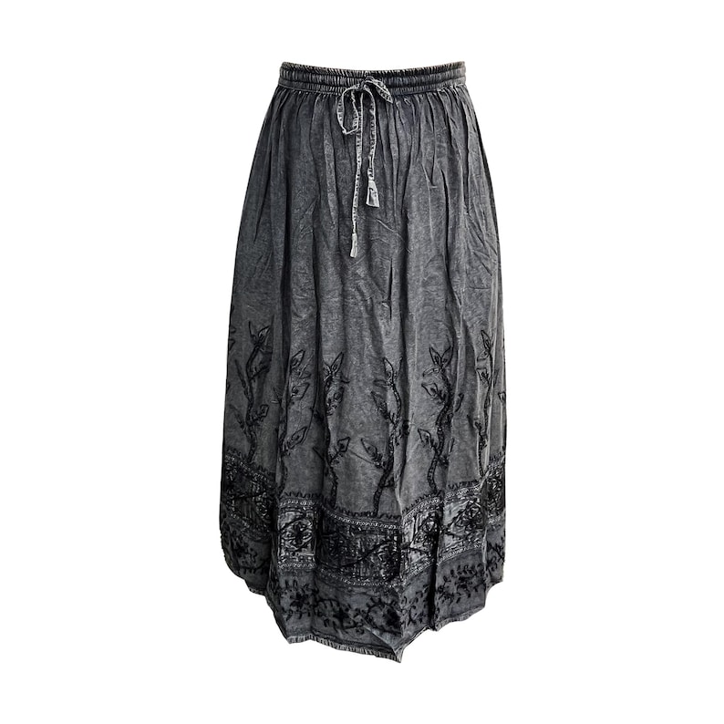 May include: A gray maxi skirt with a drawstring waist and a decorative black floral pattern along the hem and vertical accents. The skirt is made of a soft, flowing fabric, perfect for casual wear.