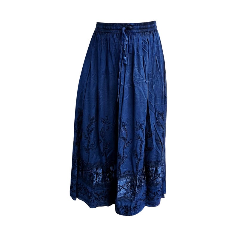 May include: A long, navy blue skirt with an elastic waistband and drawstring. The skirt features intricate black embroidered floral patterns along the hem and lower portion. The fabric has a slightly textured appearance.