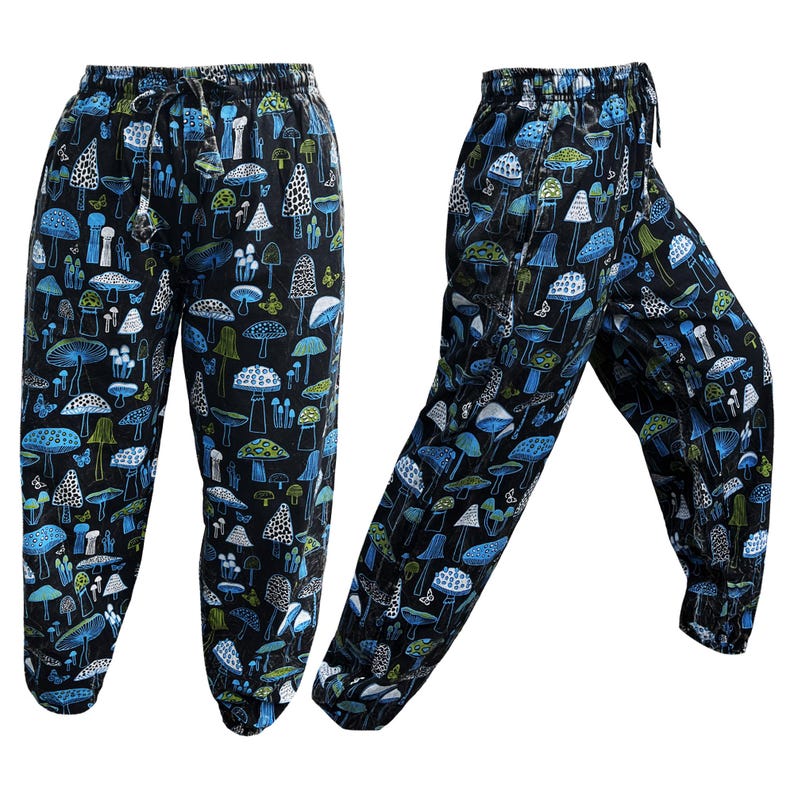 May include: Black trousers with a blue and white mushroom print. The trousers have an elastic waistband and a drawstring.