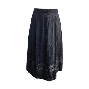 May include: A black skirt with an elastic waistband and drawstring. The skirt has a flowing silhouette and features embroidered floral patterns near the hem. The fabric appears to have a slight sheen.