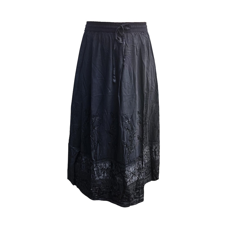 May include: A black skirt with an elastic waistband and drawstring. The skirt has a flowing silhouette and features embroidered floral patterns near the hem. The fabric appears to have a slight sheen.