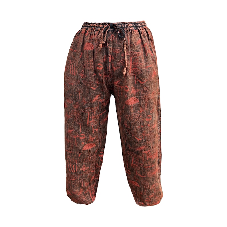 May include: Red and brown printed trousers with a drawstring waist. The trousers have a mushroom pattern.