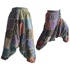 May include: Two pairs of patchwork harem trousers. The trousers feature a variety of colours including purple, blue, orange, and green. The fabric is stitched together in a patchwork design. They have an elasticated waistband and a loose, comfortable fit.
