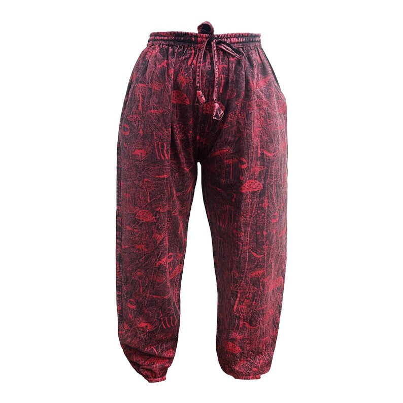 May include: Red trousers with a black and white print of abstract shapes. The trousers have an elastic waistband with a drawstring.