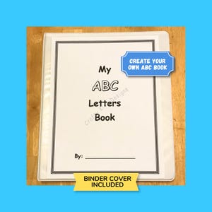 May include: A white binder with the text "My ABC Letters Book" in a black frame. The cover includes the text "Create Your Own ABC Book" and "Binder Cover Included". The background is a light wood surface.
