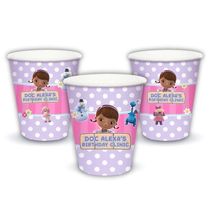 May include: Three purple and white polka dot paper cups with a pink stripe and a Doc McStuffins character design. The cups say "Doc Alexa's Birthday Clinic".