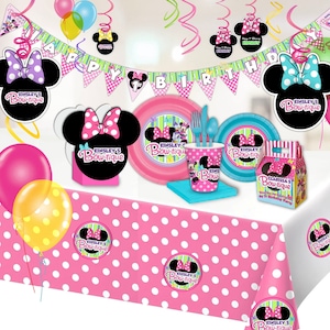 Puede incluir: Una escena festiva de fiesta de cumplea&ntilde;os con decoraciones tem&aacute;ticas de Minnie Mouse. Incluye un mantel rosa con lunares blancos, globos, platos, vasos y una pancarta que dice "Happy Birthday". La combinaci&oacute;n de colores es rosa, negro y blanco.