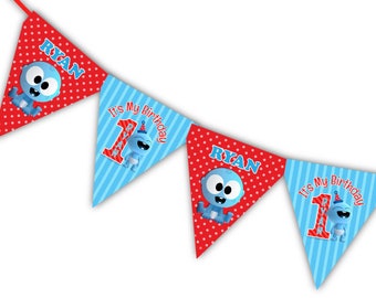 May include: A blue and red triangular banner with the words "It's My Birthday" and "Ryan" on each flag. The banner is decorated with white polka dots and a cartoon blue octopus.