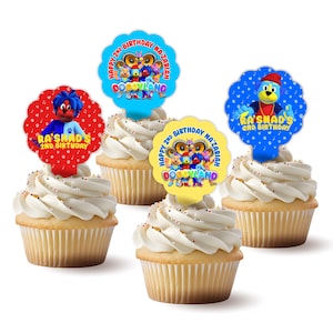 May include: Four cupcakes decorated with colorful character toppers featuring the text "Happy 2nd Birthday Na'Zariah Doggyland" and "Ra'Shad's 2nd Birthday".