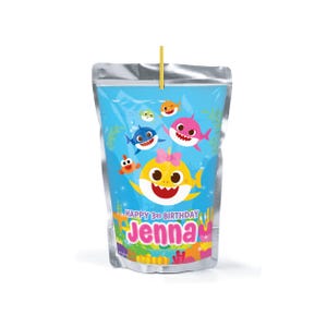 Könnte beinhalten: Ein Saftbeutel mit blauem Hintergrund mit Cartoon-Haien und dem Text "HAPPY 3RD BIRTHDAY JENNA". Der Beutel hat eine silberne Oberseite und einen gelben Strohhalm.