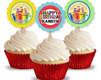 May include: Three colourful cupcake toppers with a cartoon crayon theme. The toppers feature the text "Happy 1st Birthday" and the names "Kaiden" and "Kamryn".