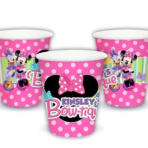 Puede incluir: Vasos de papel de lunares rosas con Minnie Mouse y Daisy Duck. Los vasos tienen un borde blanco e incluyen el texto "Kinsley's Bow-tique". Los vasos est&aacute;n decorados con un lazo de Minnie Mouse.