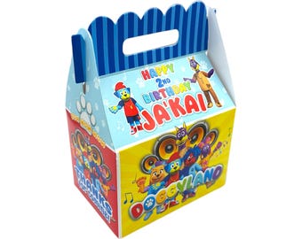 May include: A blue and yellow party favour box with a handle. The box features a cartoon dog character and the text "Happy 2nd Birthday Ja'Kai Doggyland".