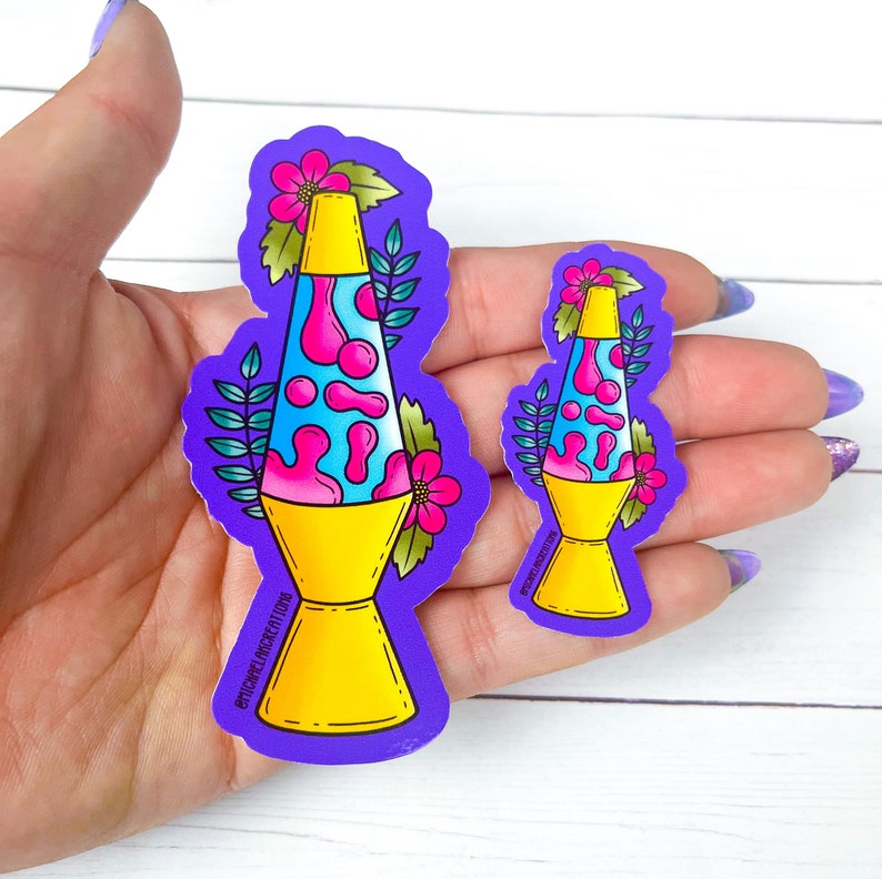 May include: Two purple stickers with a retro-style lava lamp design. The larger sticker has a yellow base, blue and pink lava, and pink flowers. The smaller sticker is the same design but smaller. Both stickers have the text "@STICKYWELLCOLLECTIBLES" on the bottom.