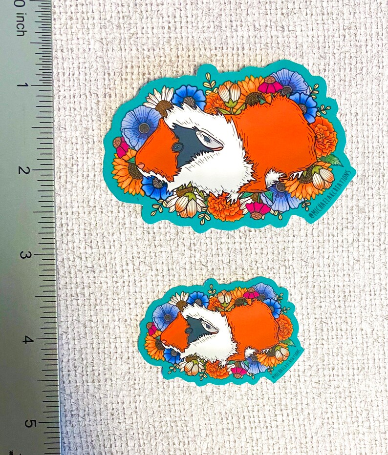 Puede incluir: Dos pegatinas con un conejillo de indias de dibujos animados rodeado de flores coloridas. El conejillo de indias es naranja y blanco con ojos negros y una nariz negra. Las flores son de varios colores, incluyendo amarillo, naranja, rojo, azul y blanco. Las pegatinas est&aacute;n sobre un fondo azul claro. El texto "@michimalillustrations" est&aacute; en la esquina inferior derecha de la pegatina m&aacute;s grande.