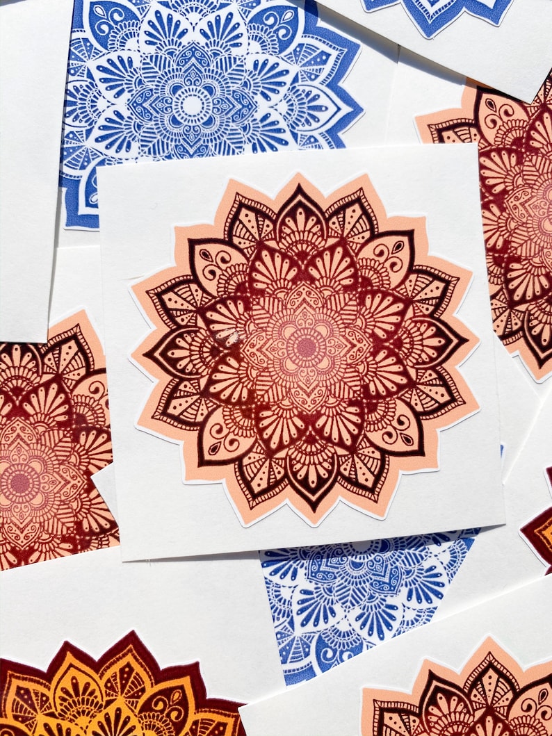 Pu&ograve; includere: Un set di quattro adesivi mandala in vari colori, tra cui blu, rosso, arancione e rosa. Gli adesivi sono stampati su carta bianca e presentano disegni intricati.