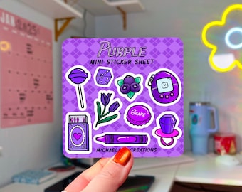 Könnte beinhalten: Lila Mini-Stickerbogen mit verschiedenen Designs zum Thema Lila, darunter ein Lollipop, ein Würfel, eine Blume, eine Traube, ein Ring, ein Tamagotchi und ein Buntstift. Der Bogen hat einen lila karierten Hintergrund und den Text "Purple Mini Sticker Sheet" und "Michael Creations".