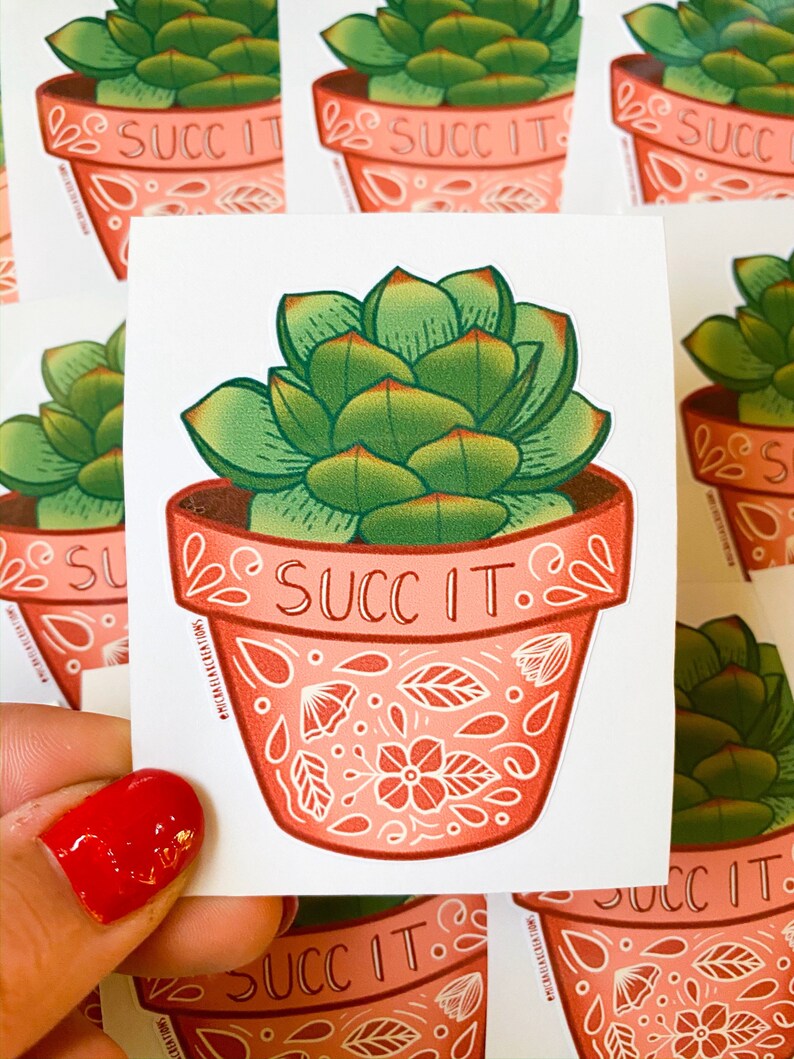 May include: A sticker featuring a succulent plant in a pink pot with white floral designs. The pot has the text "SUCC IT" written on it.