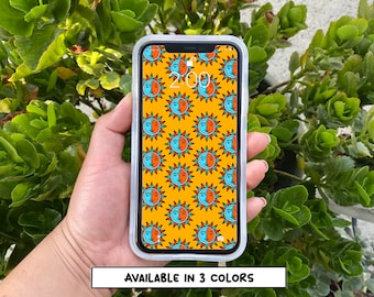 May include: A clear phone case with a yellow background and a repeating pattern of blue and orange suns and moons. The text "AVAILABLE IN 3 COLORS" is at the bottom of the image.